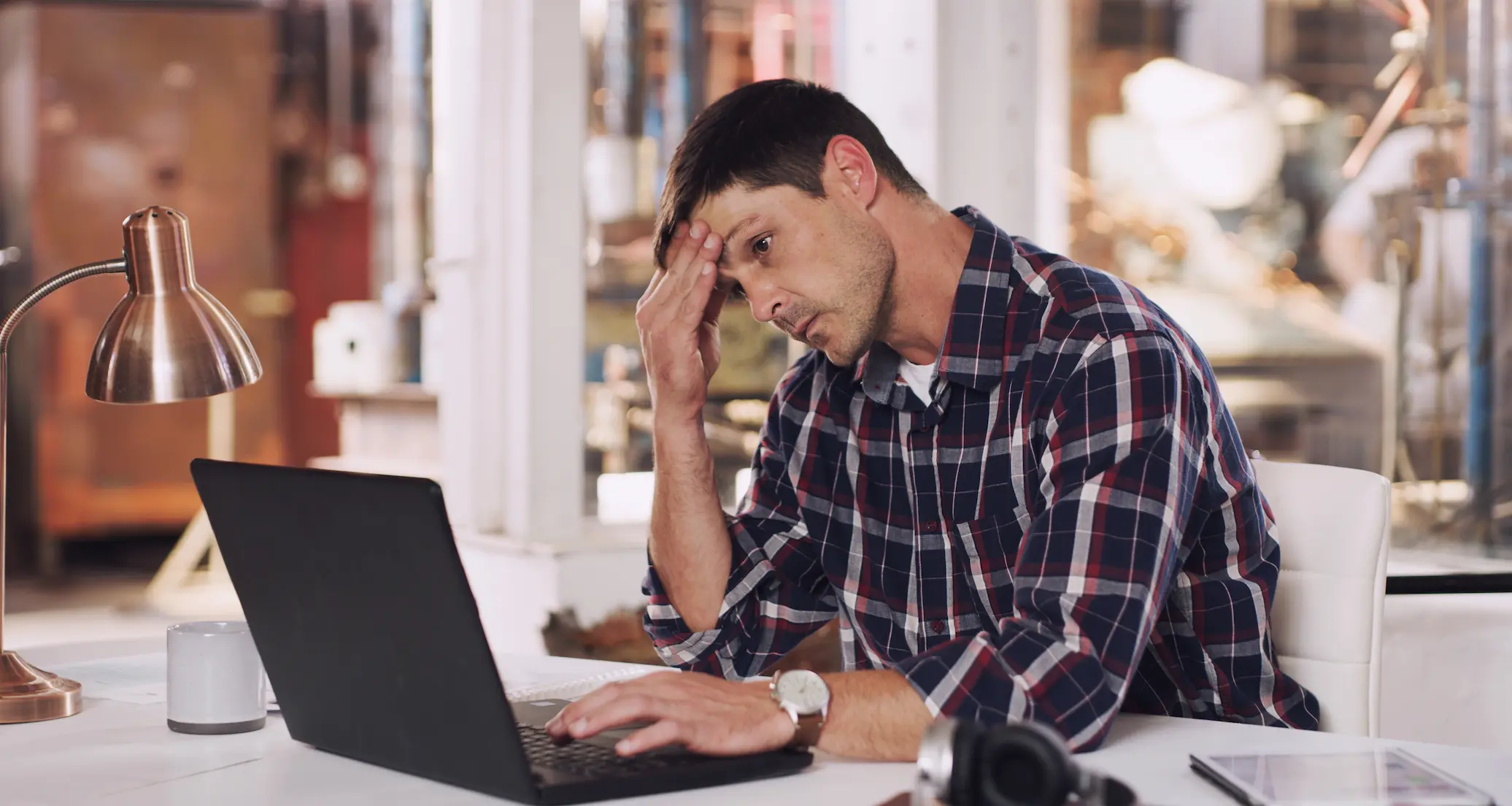 Stock photo showing frustrated business owner looking at laptop computer